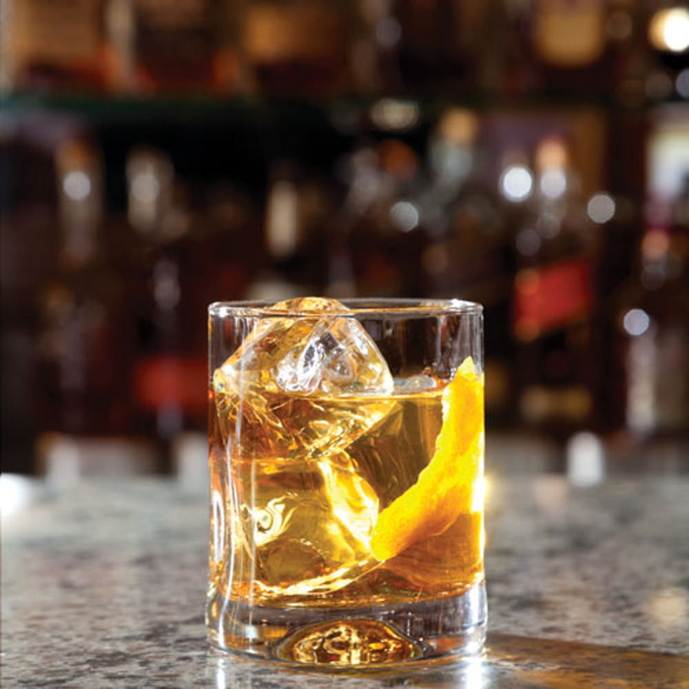 Whiskey glass on a quartz countertop.