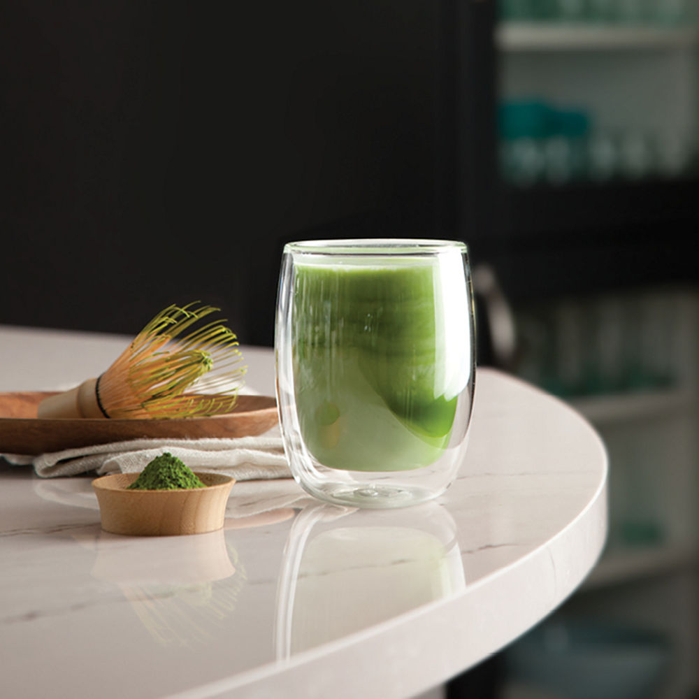 A glass of fresh juice on top of a Cambria quartz table.