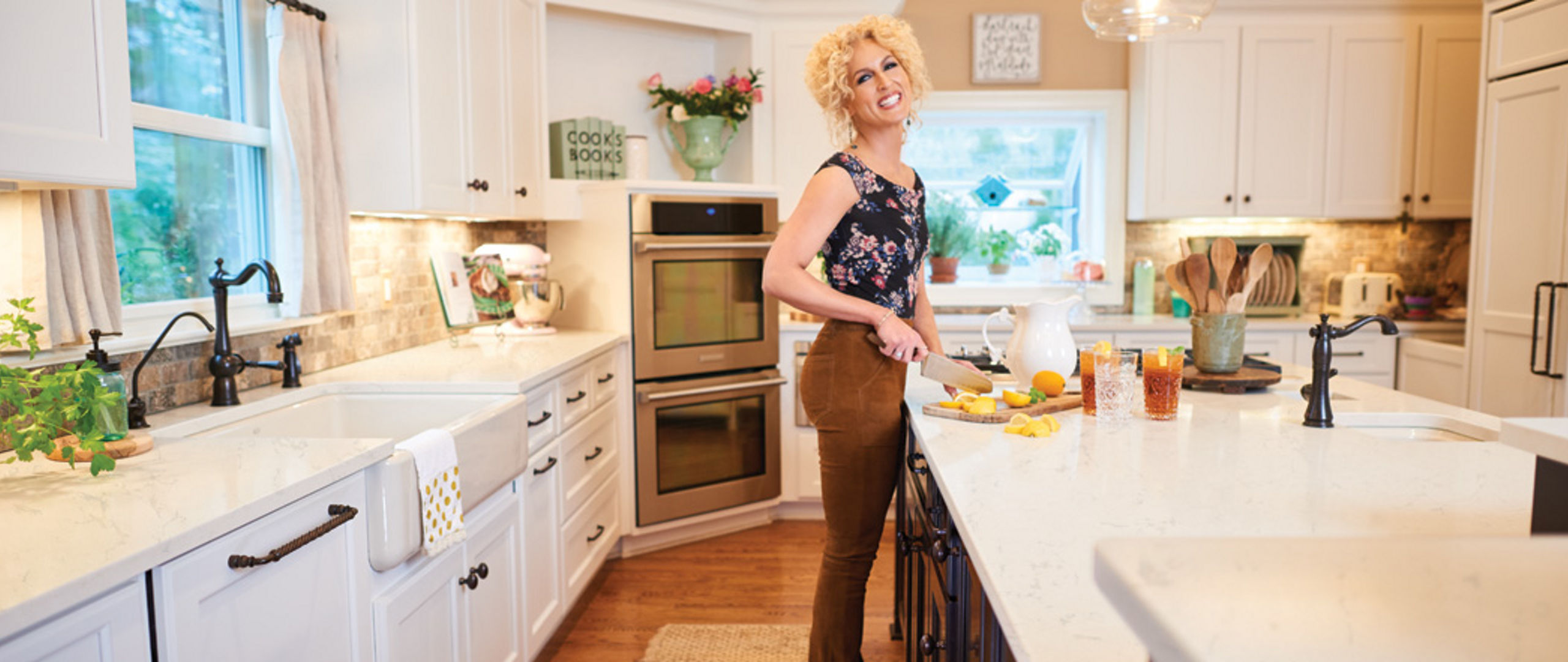 Photograph of Kimberly Schlapman cutting fruit on a cutting board on a kitchen island.