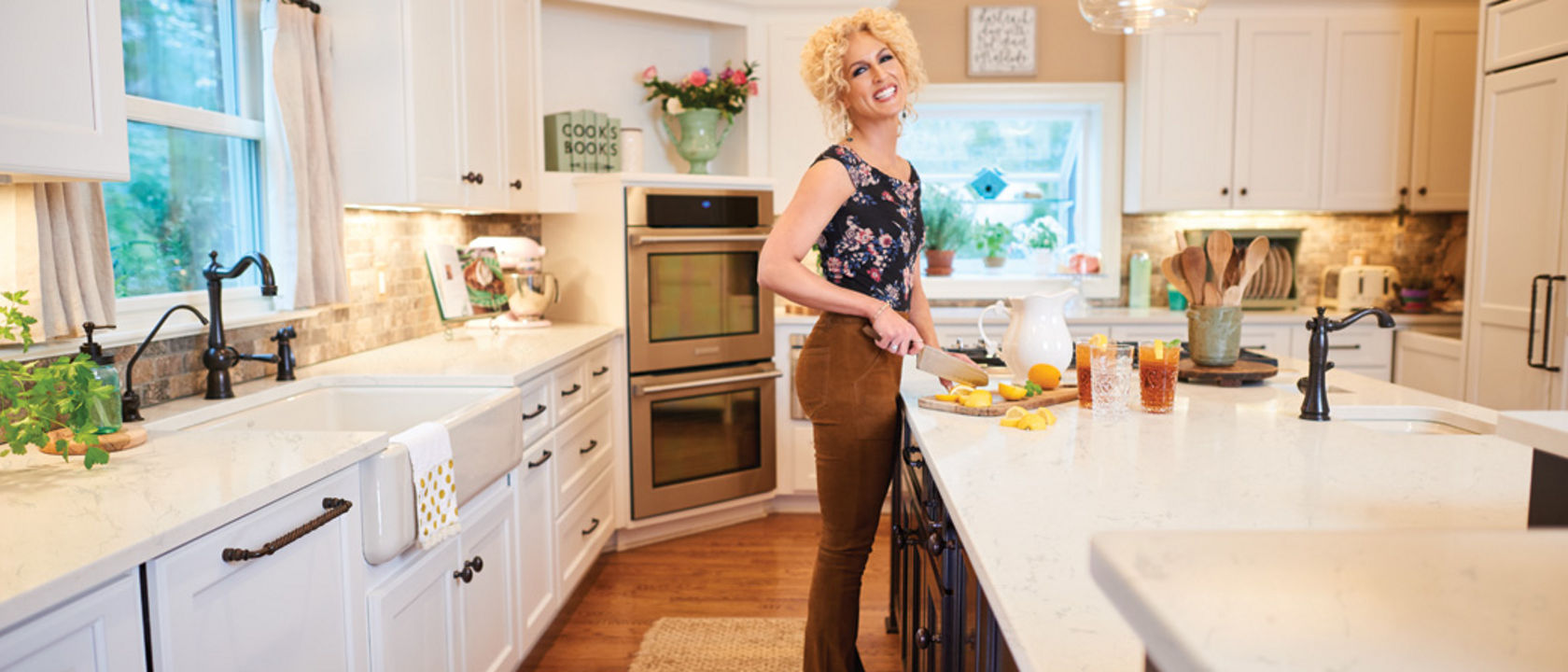 Photograph of Kimberly Schlapman cutting fruit on a cutting board on a kitchen island.