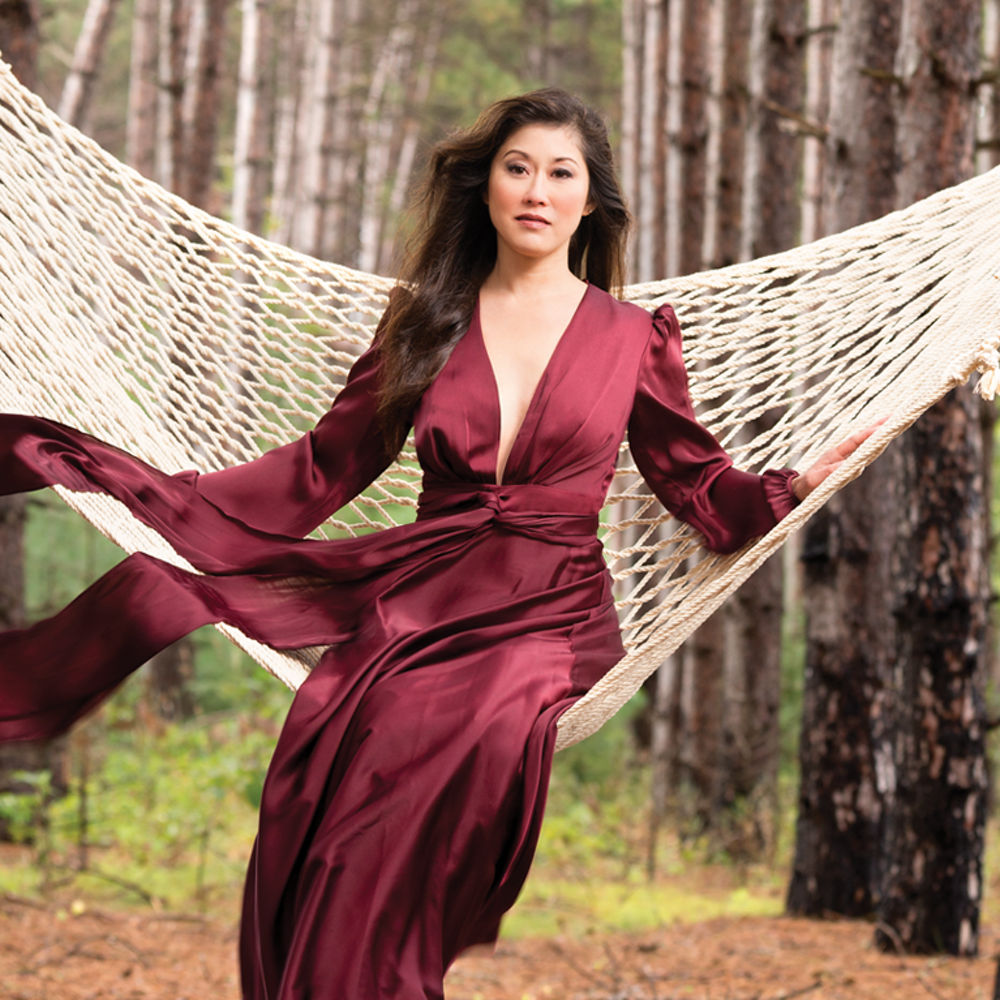 Kristi Yamaguchi sitting on a hammock in a forest.