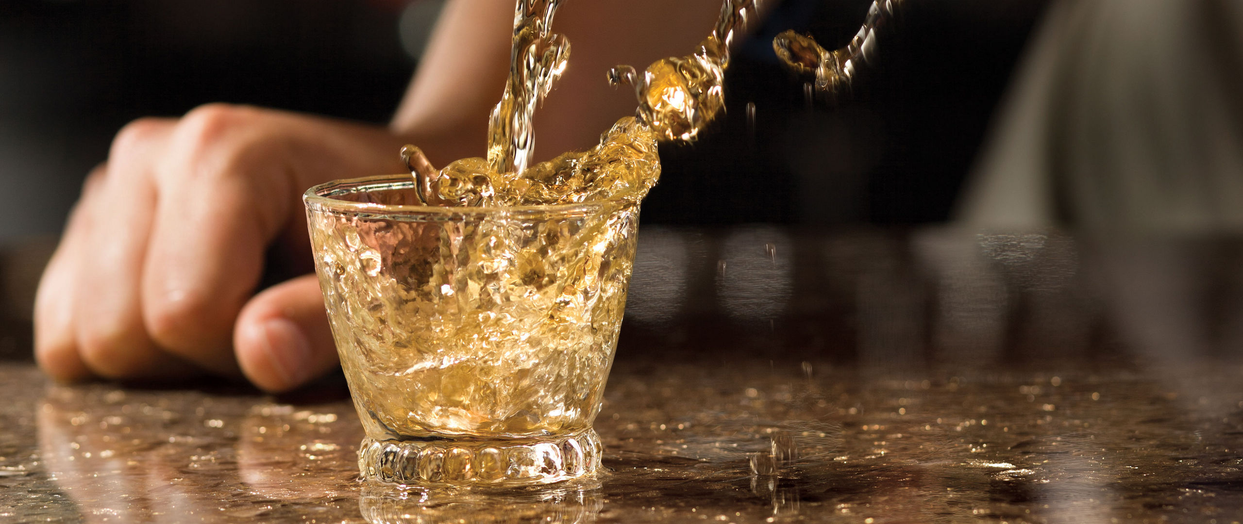 Tequilla being poured into a glass.