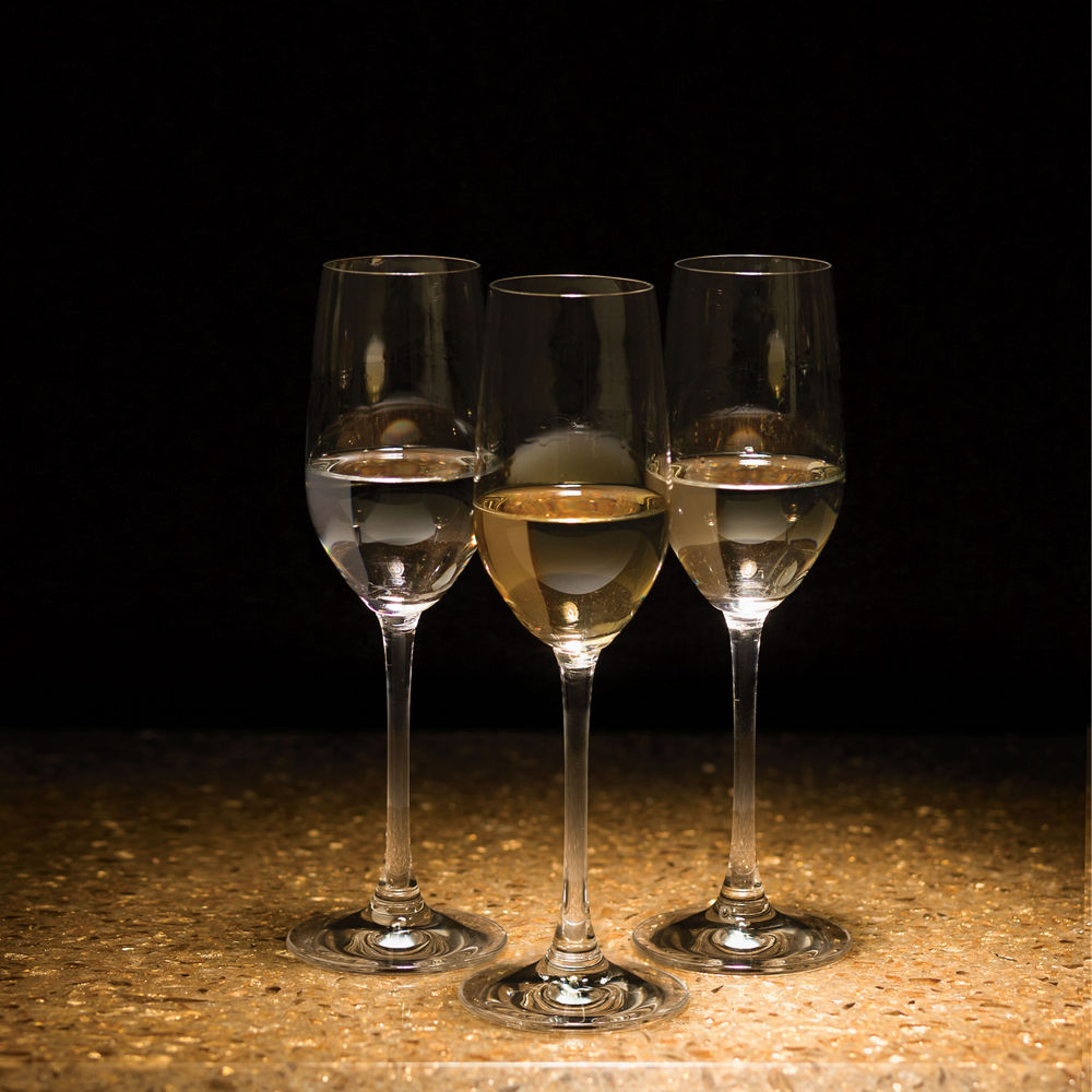 Three glasses of tequilla sitting on top of Cambria Rosslyn quartz countertops.