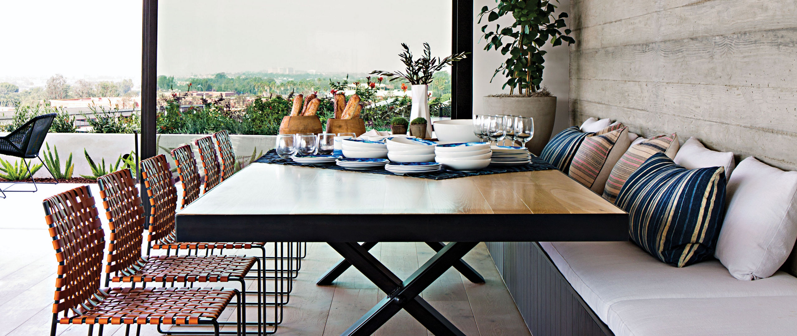 a farmhouse style dining room, with a cushioned bench on one side and chairs on the other.