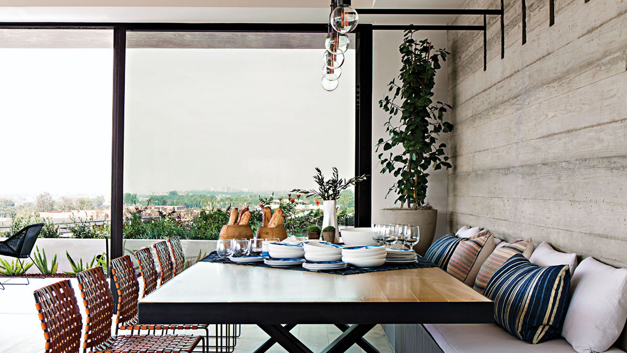 a farmhouse style dining room, with a cushioned bench on one side and chairs on the other.