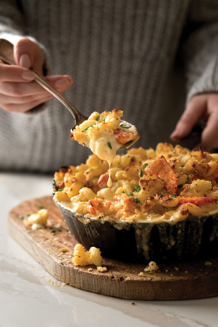 Decadent lobster mac and cheese served in a kitchen with white quartz countertops.
