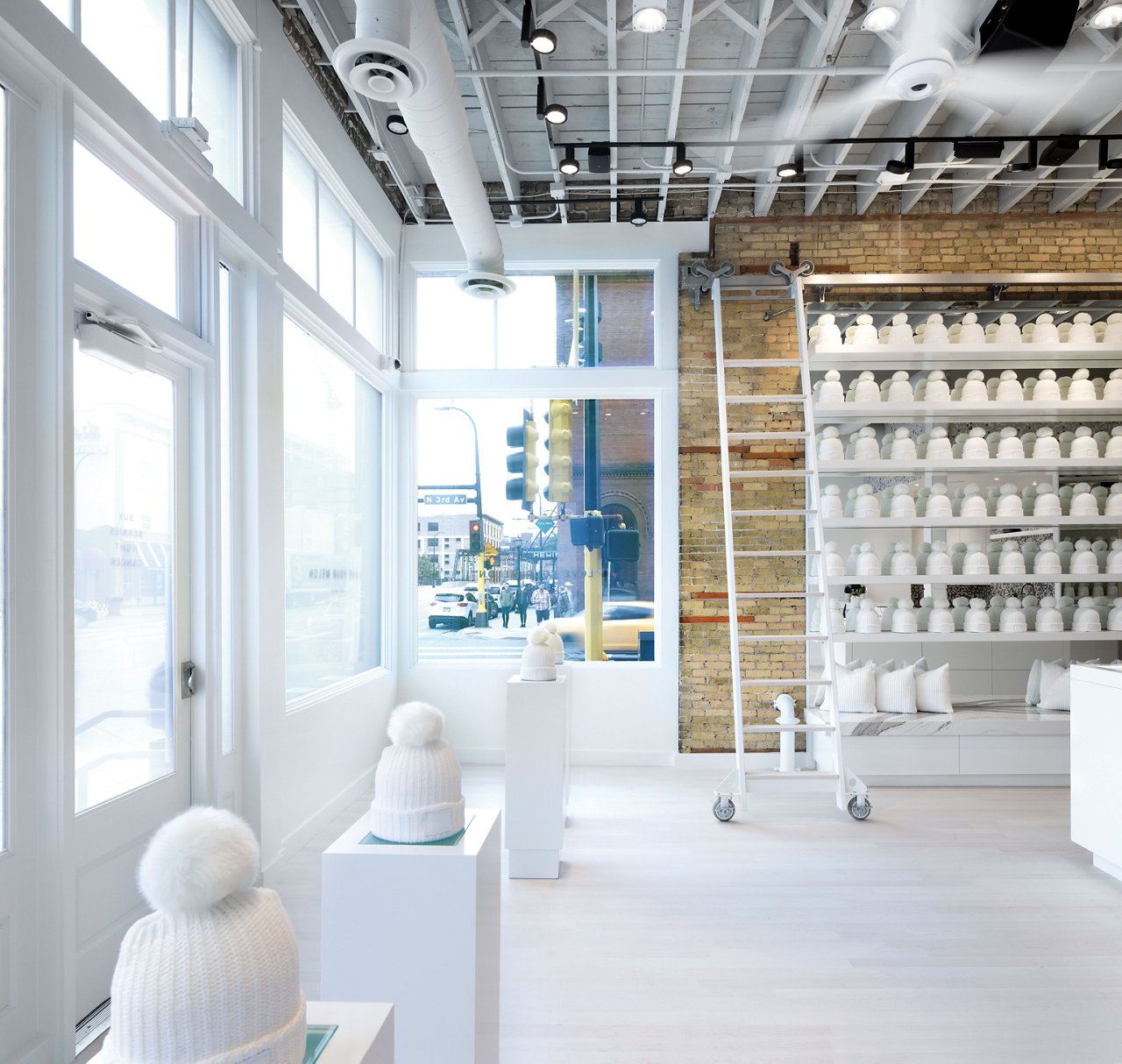 The Love Your Melon storefront, with custom-finished bleached-maple floors warm up the bright, neutral space.