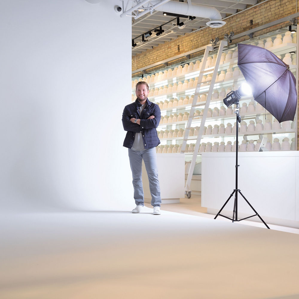 Love Your Melon founder Zachary Quinn poses in front of a seamless white backdrop devoted to photo shoots.
