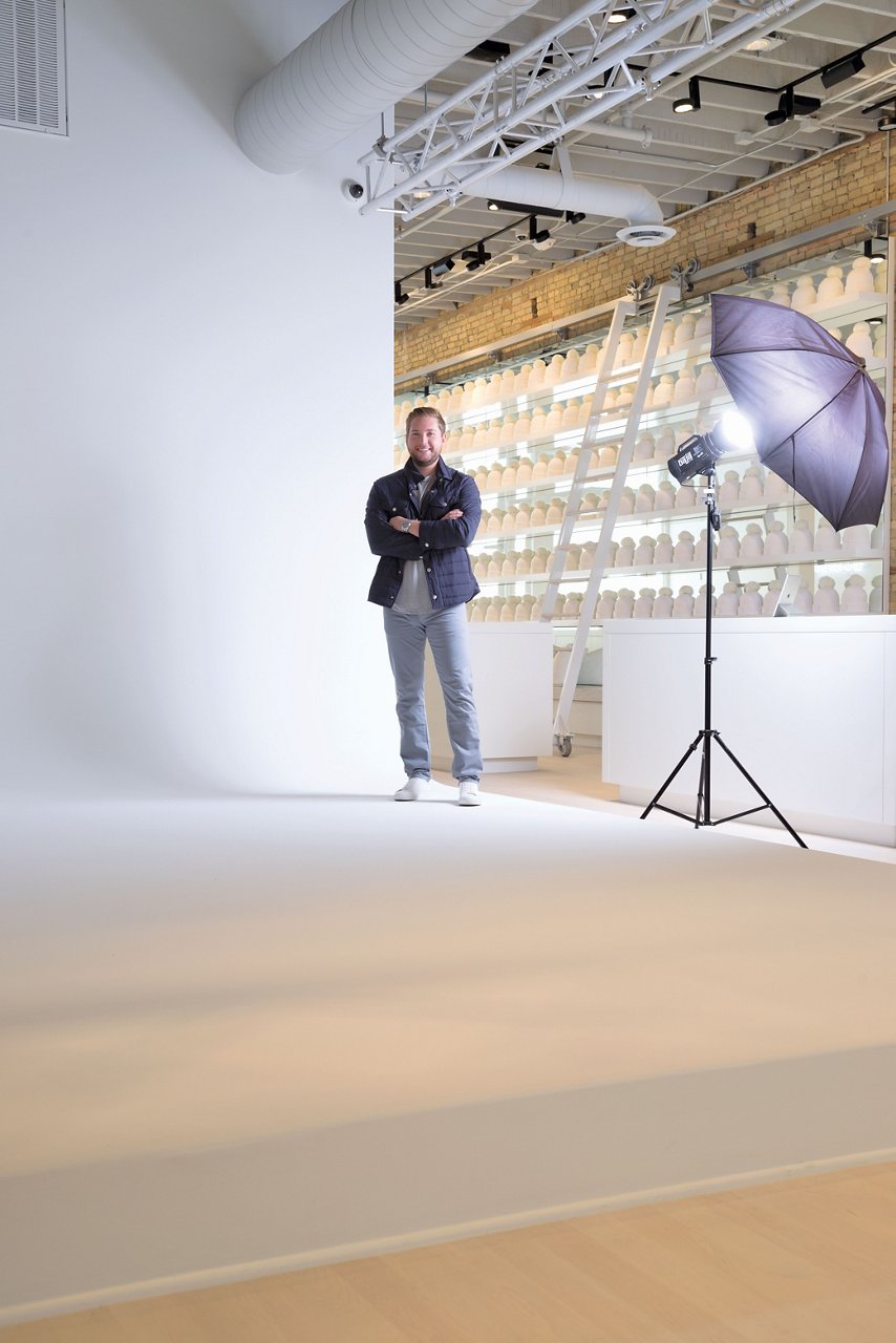 Love Your Melon founder Zachary Quinn poses in front of a seamless white backdrop devoted to photo shoots.