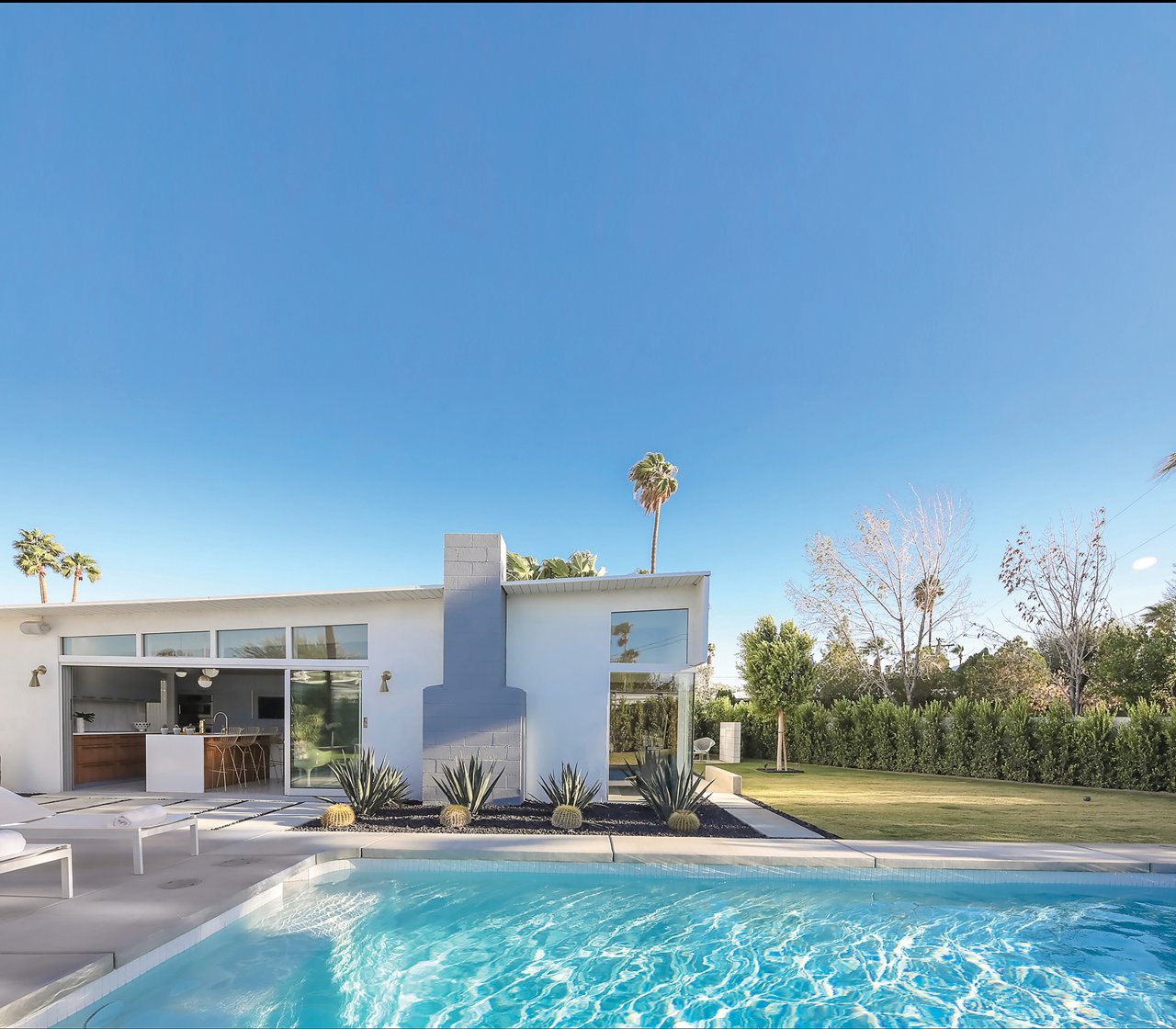 Exterior shot of a mid-century modern house with a gorgeous blue pool.