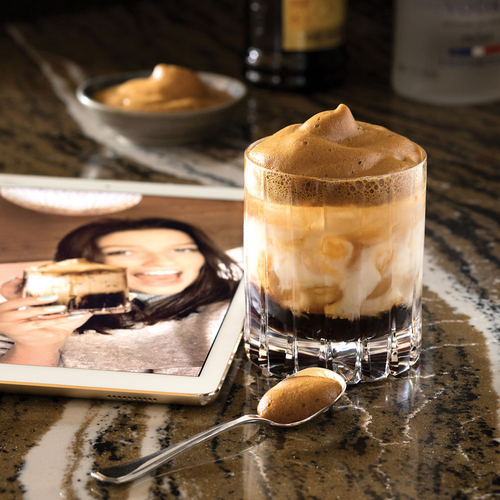 A dessert, spoon, and photo sit upon a Cambria Golden Dragon quartz countertop.