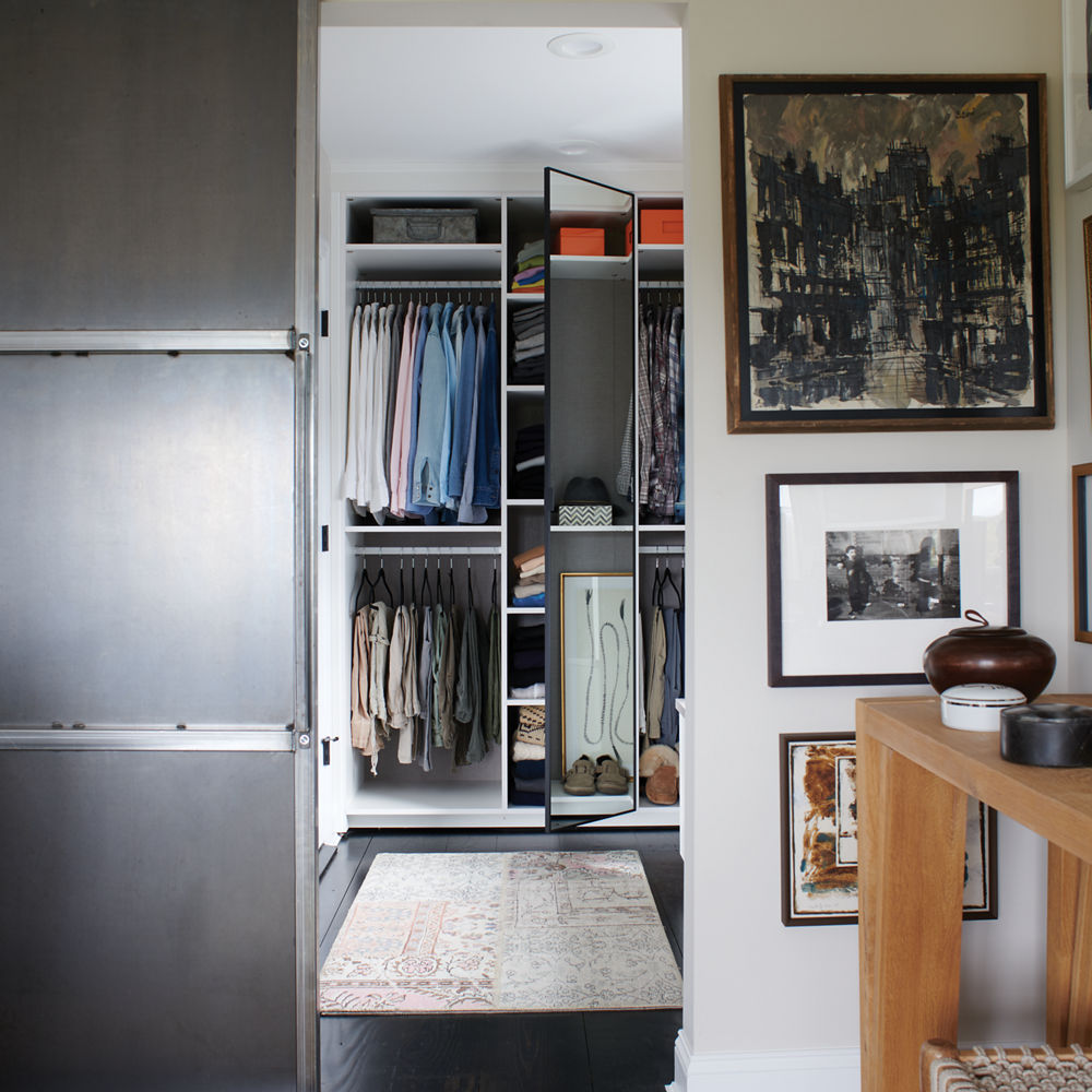 Wall space displaying a collection of modern art with a closet entry in the center.