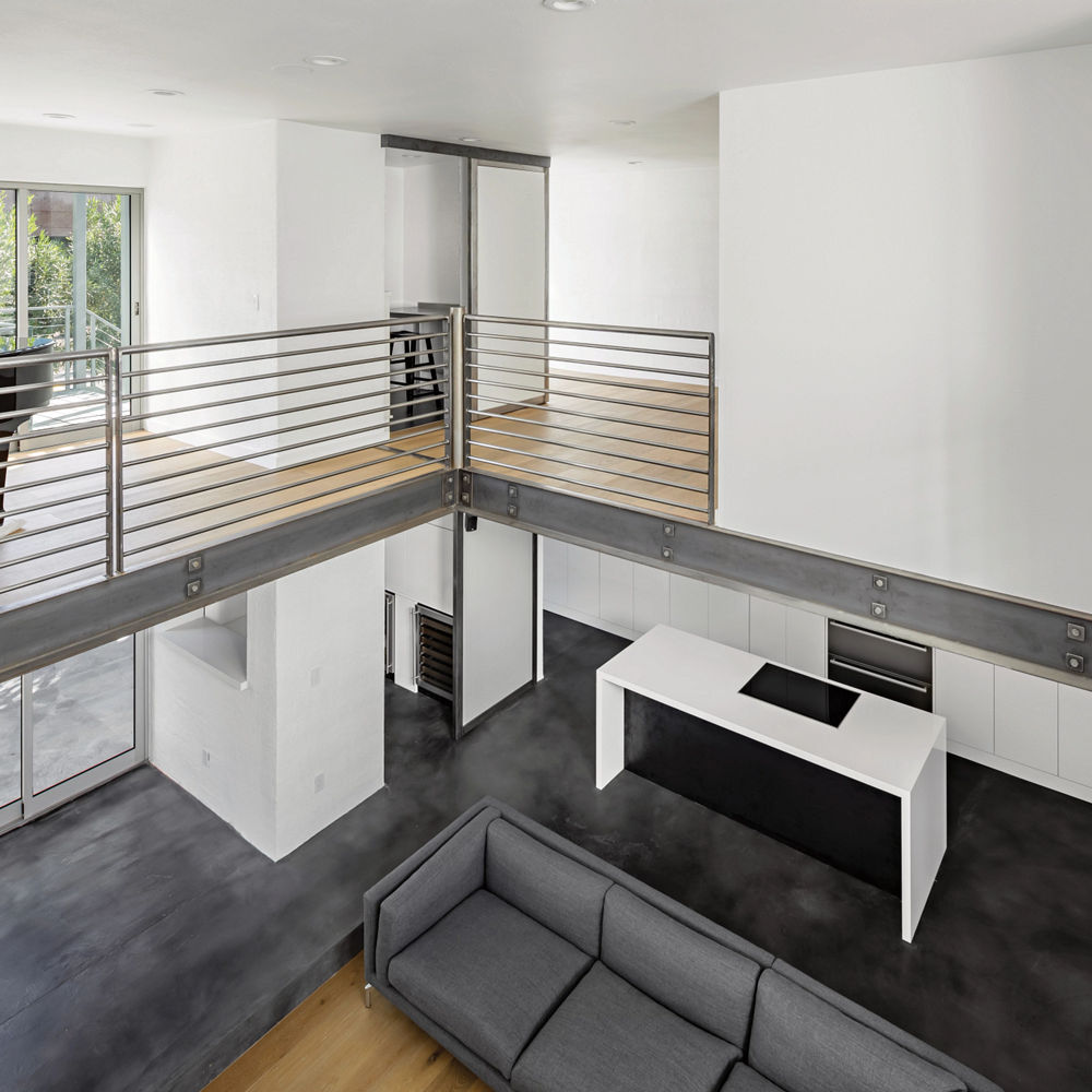 A loft overlooking a living room and kitchen.