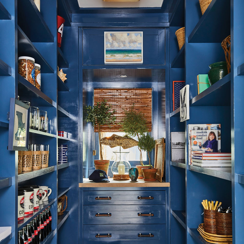 a fun, and playful pantry with dark blue cabinets and shelving, wooden accents, and plenty of space for storage. 