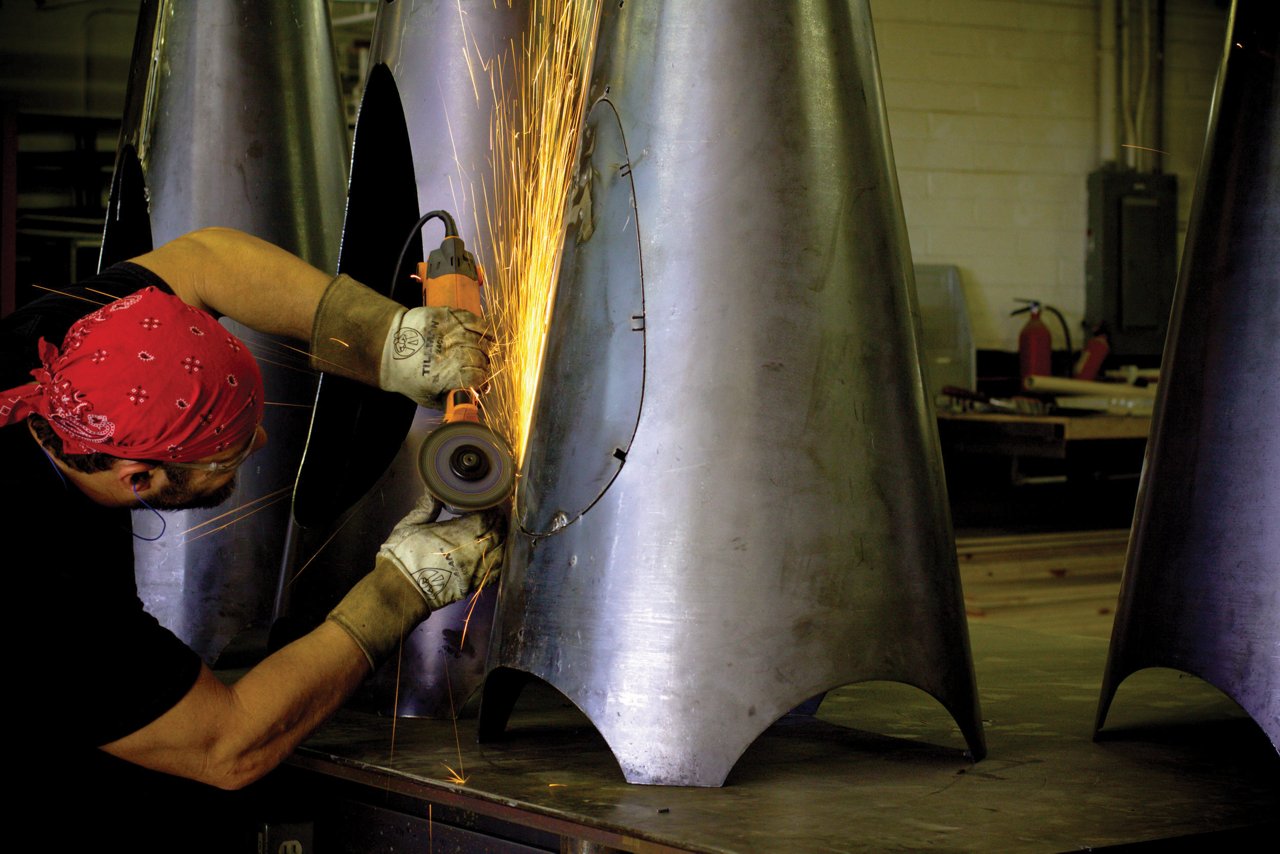 A man welding a piece of artwork.