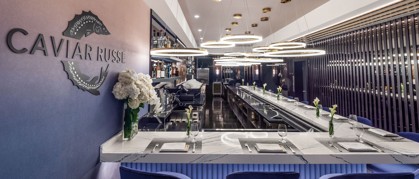 a bar at Caviar Russe topped with white quartz countertops.