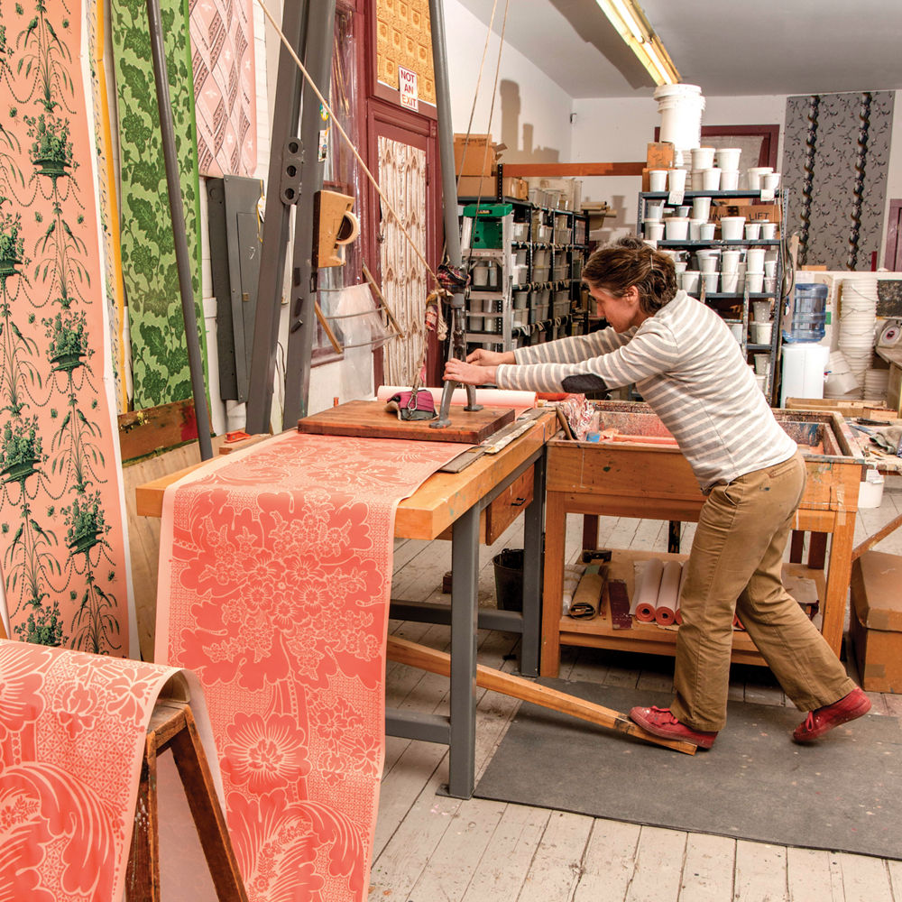 Adelphi applies patterns via carved blocks, pressing and drying repeatedly to layer shapes and colors.