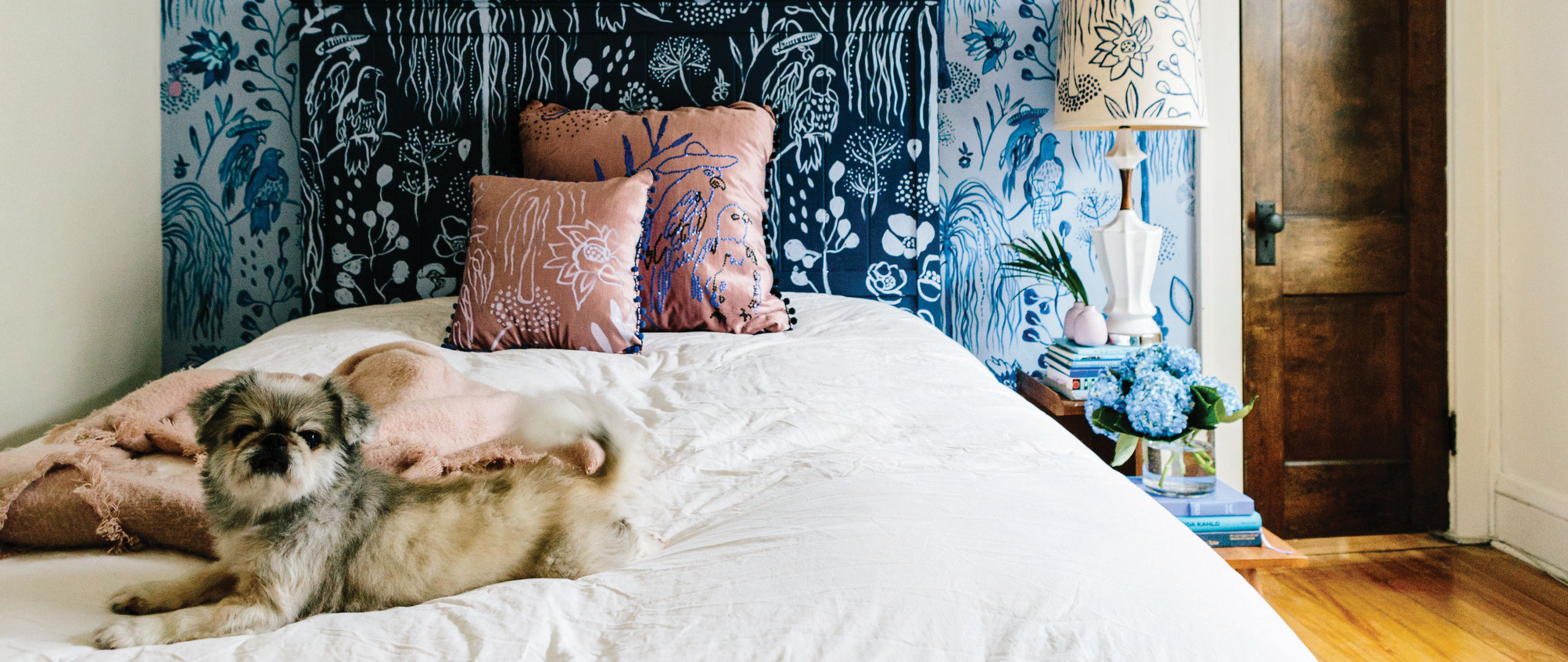 A bedroom with a gorgeous blue painted mural.