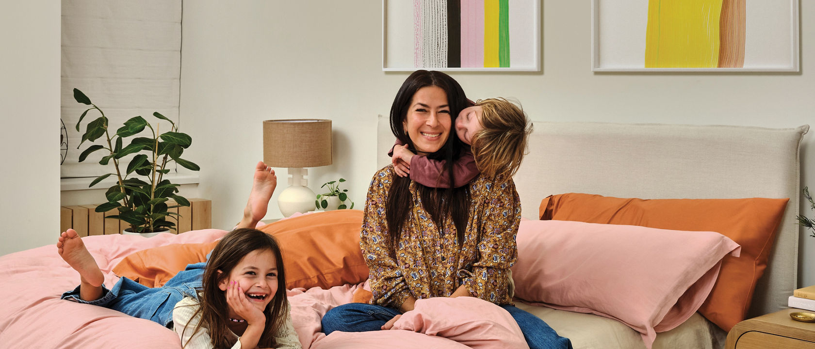 Rebecca Minkoff and her kids posing in a colorful bedroom.