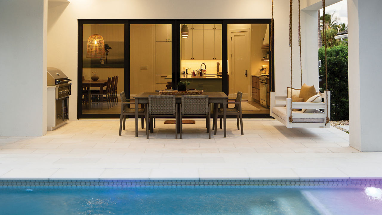 an exterior shot of a contemporary home featuring a pool and outdoor seating area. 