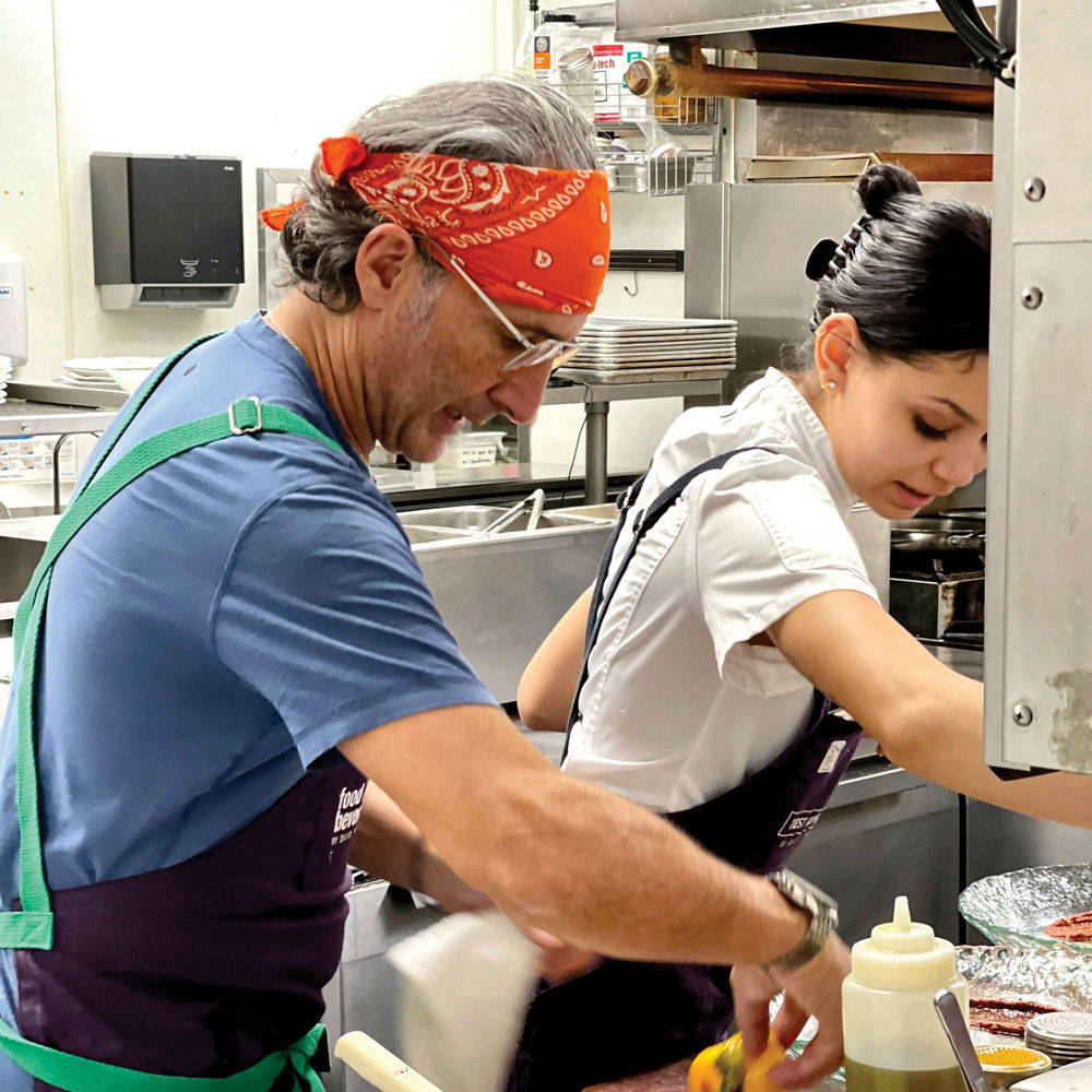 2 chefs cooking a delicious meal at Fima's Minneapolis restaurant.