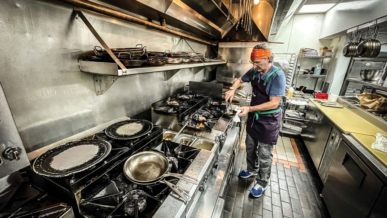 A chef cooking over a range at Fhima's Minneapolis restaurant.