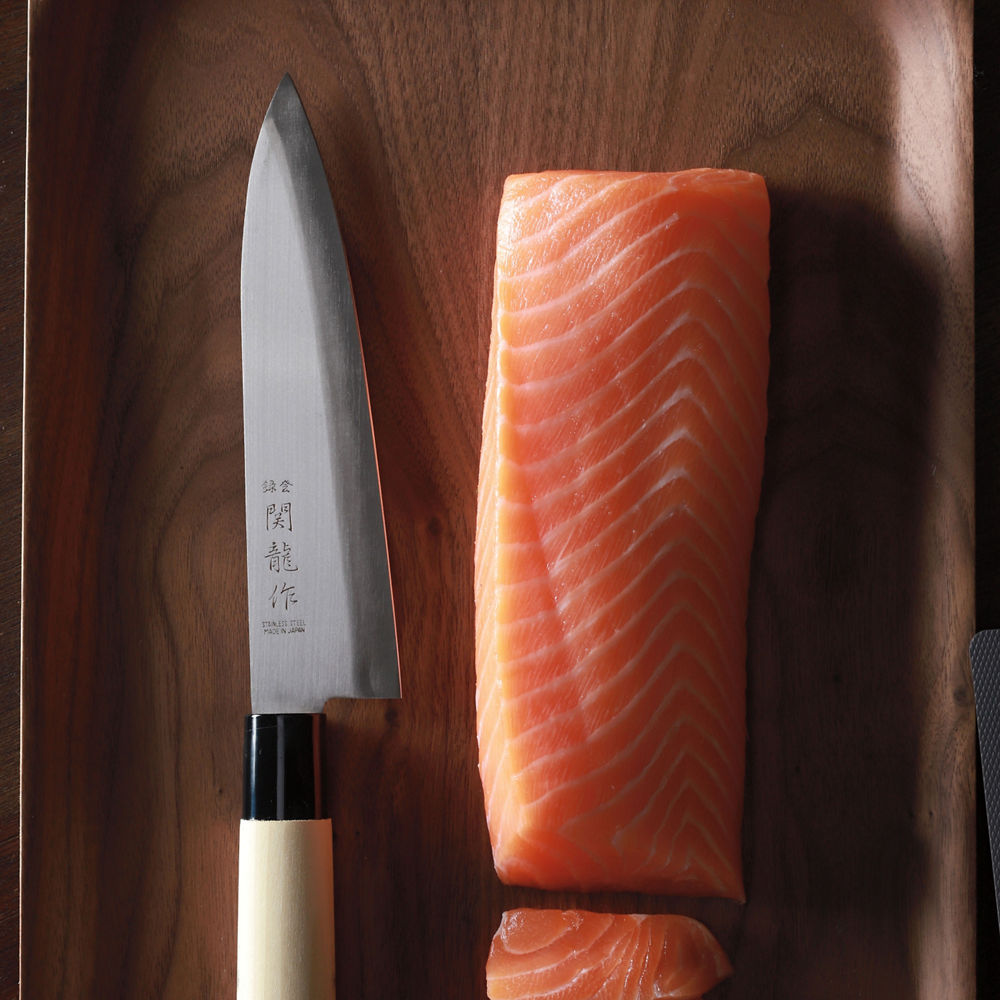 A piece of salmon and a salmon kinfe.