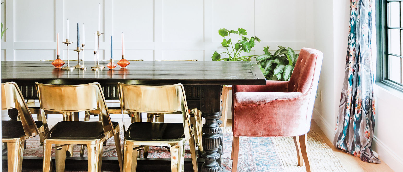 A colorful dining room with a printed rug and wooden chairs