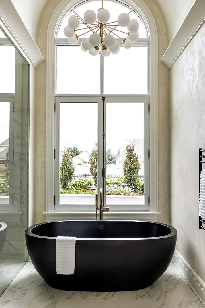 A black concrete bathtub in a brightly lit bathroom.