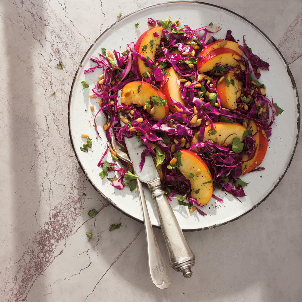 A deliciously plated Summer Slaw with Peaches and Parsley sitting atop a Cambria Hailey quartz tabletop