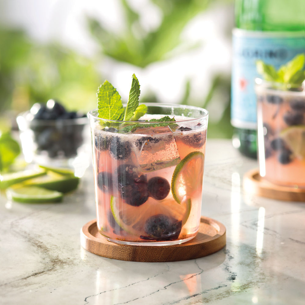 A drink on a Lakedale quartz countertop with greenery in the background