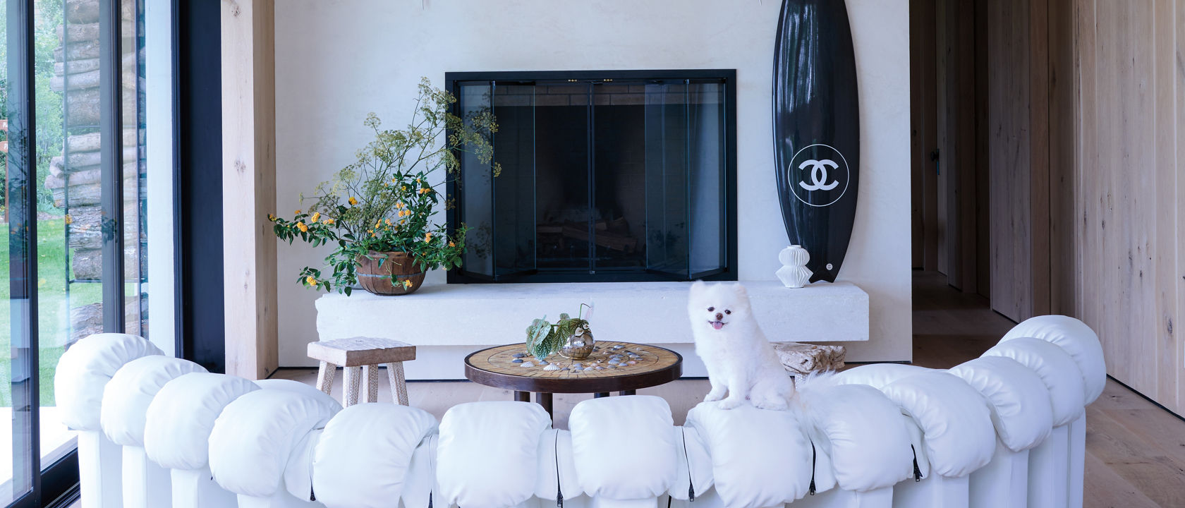 Sasha Bikoff's living room with a couch, fireplace, table and two dogs.