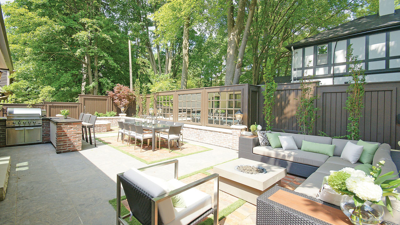 An exterior patio of a home with a luxurious bbq area, an outdoor dining area, and plenty of seating around a firepit.