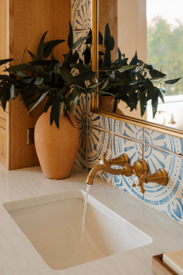 A bathroom with colorful wallpaper and Delgatie quartz countertops