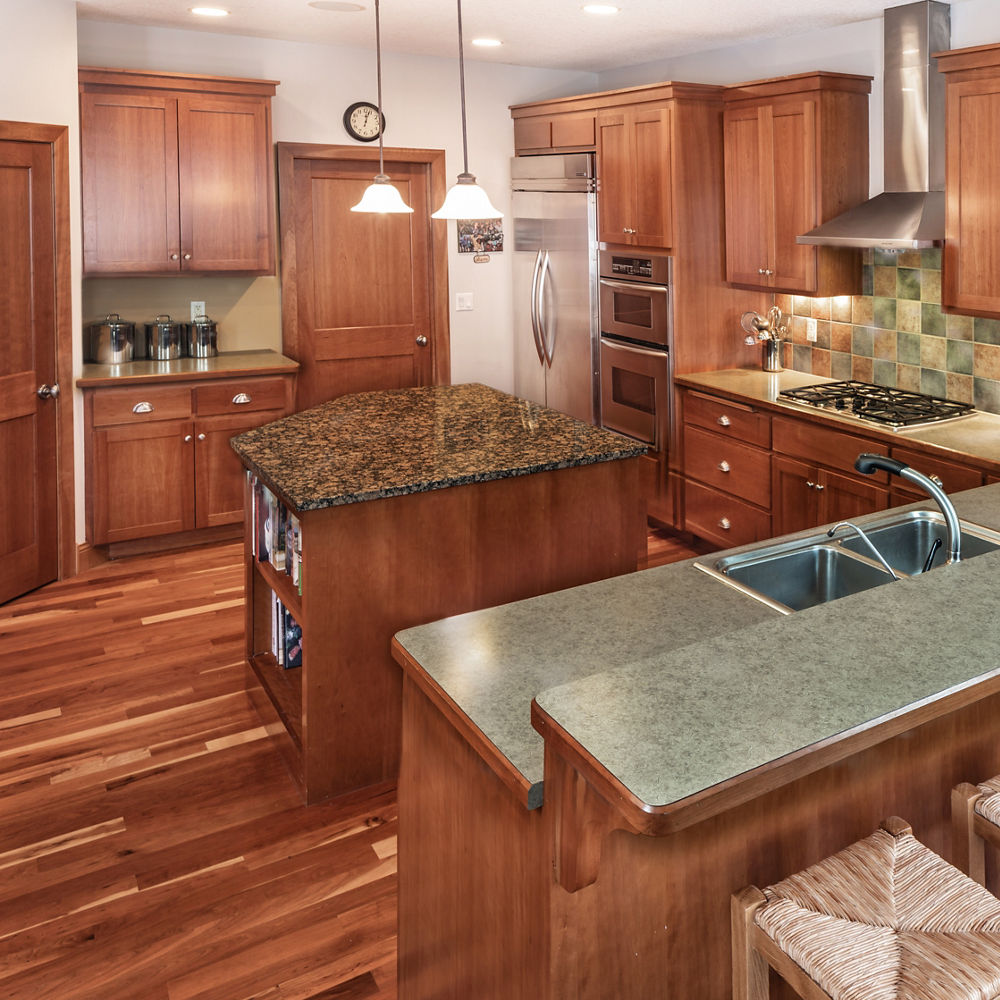 An outdated kitchen with greenish-brown countertops that are low-performance