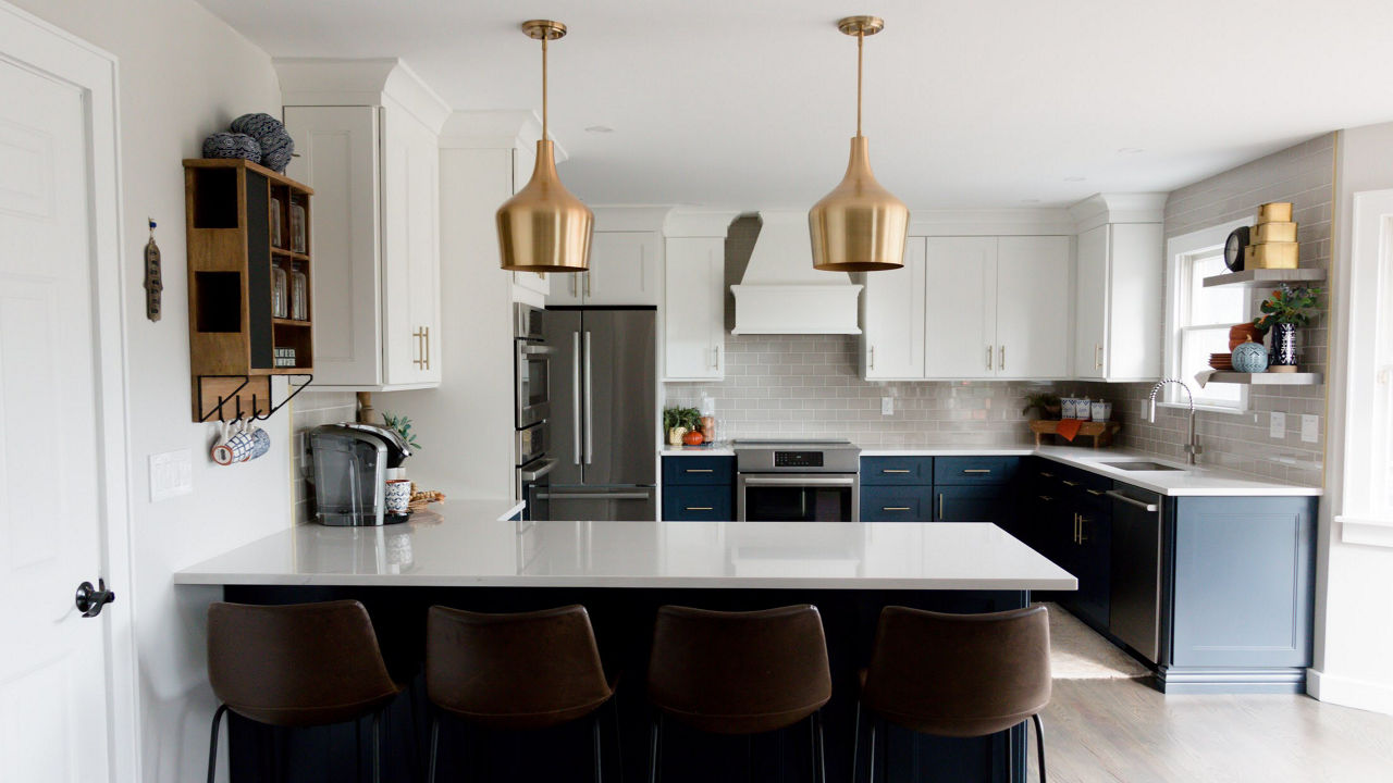 Photograph of a kitchen with navy blue lower cabinets, focused on the kitchen's island.