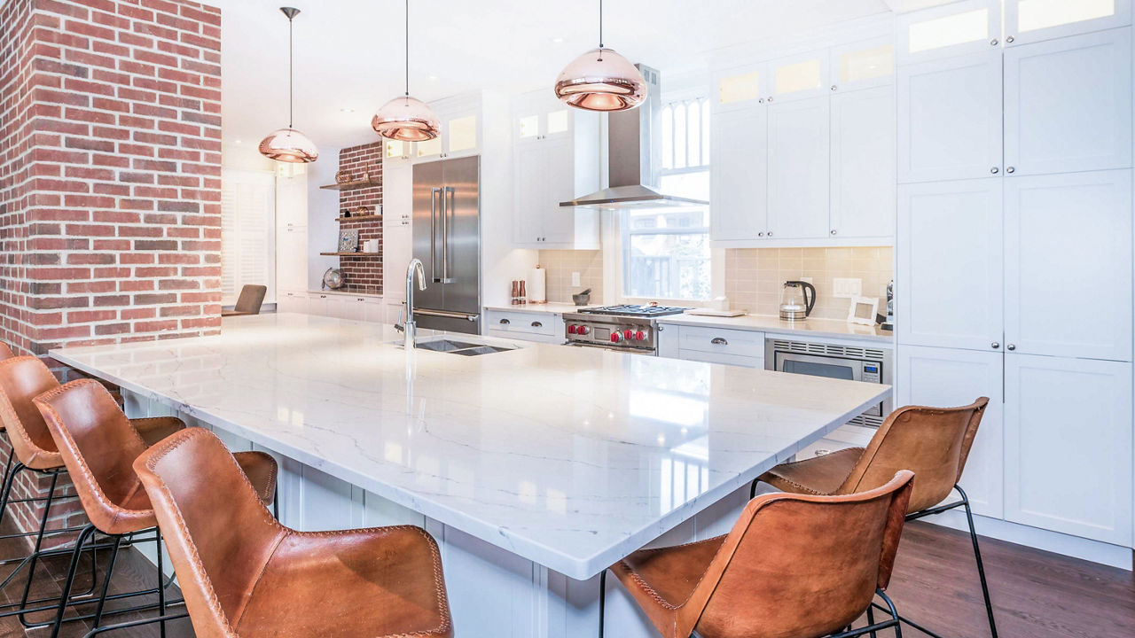 Cambria Ella quartz island kitchen countertop in a kitchen with dramatic mixed brick and quartz elements.