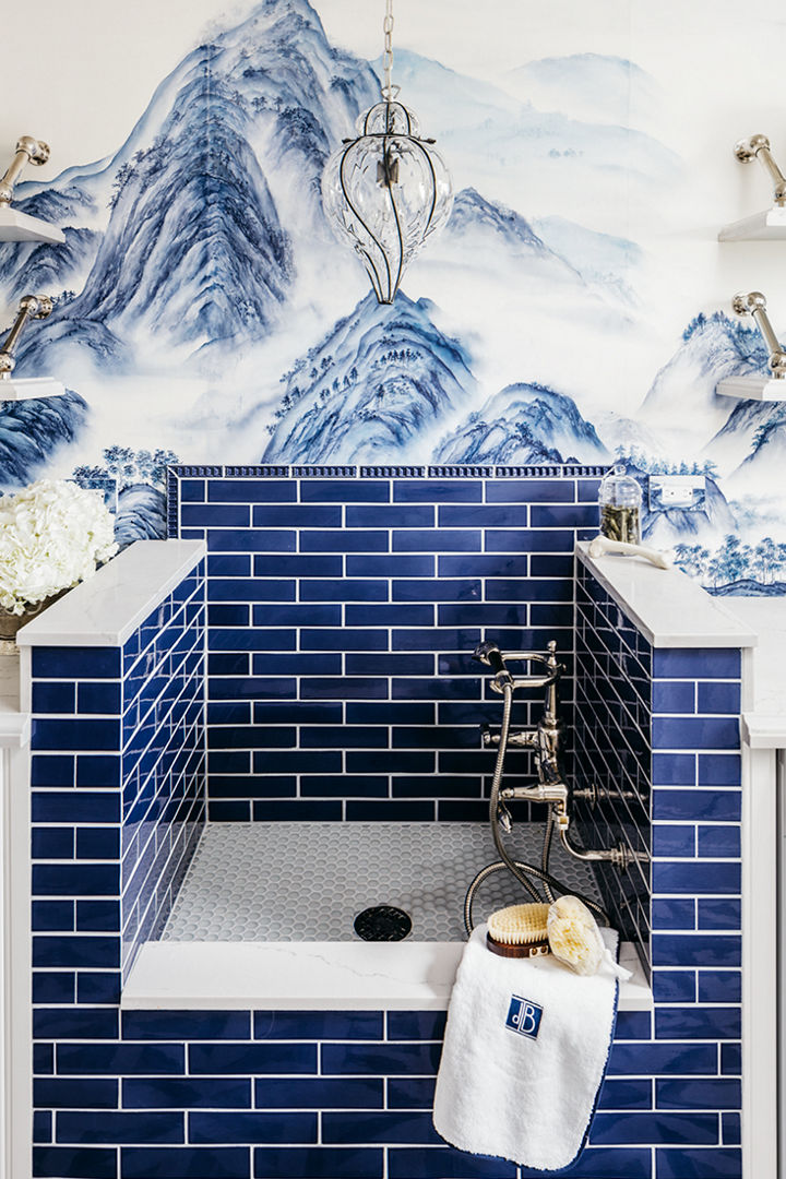a blue tiled pet shower with gorgeous blue mountain wallpaper and white quartz features. 