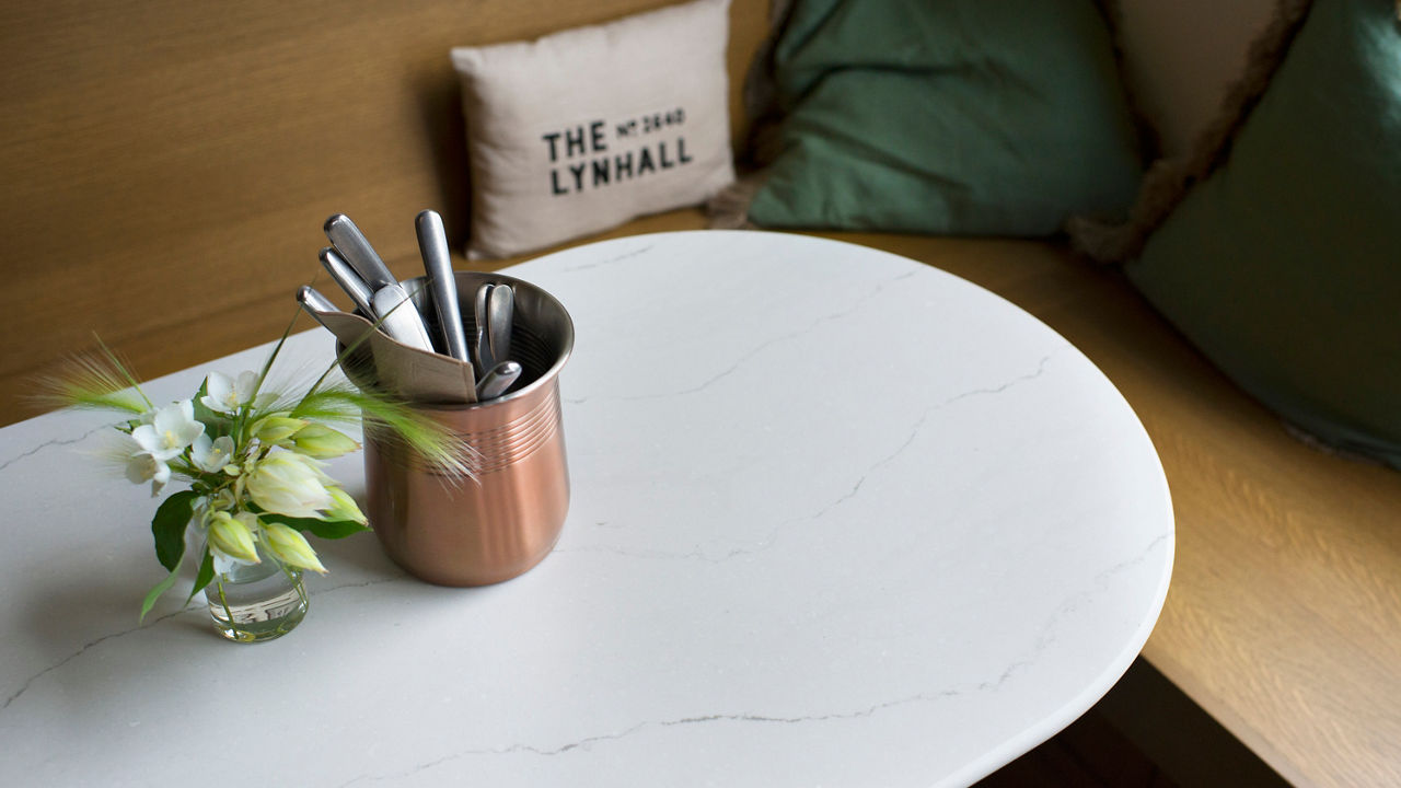 A table around a bench at The Lynhall featuring a Cambria Ella Matte quartz countertop.