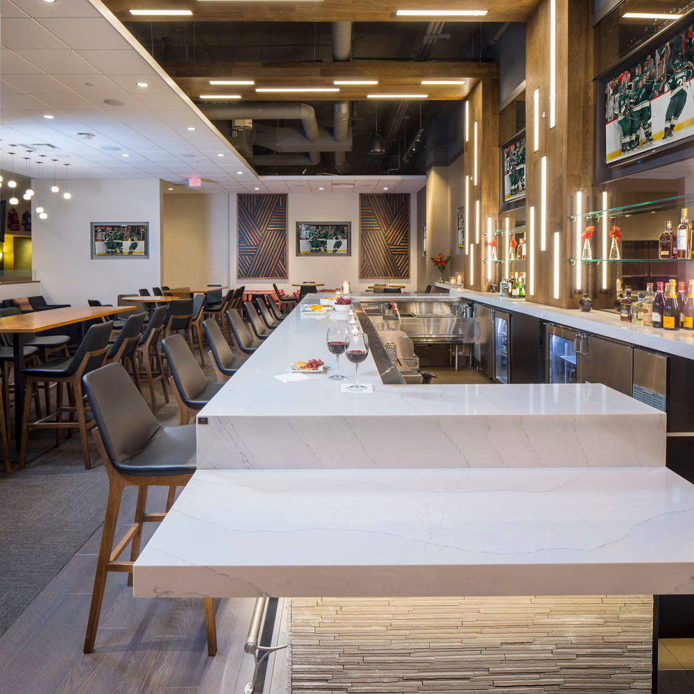 an exclusive Xcel Energy Cente bar showcases inventive lighting applications, white quartz countertops, and intriguing texture.