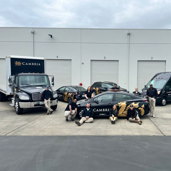 Cambria SDC team posing in front of Cambria vehicles