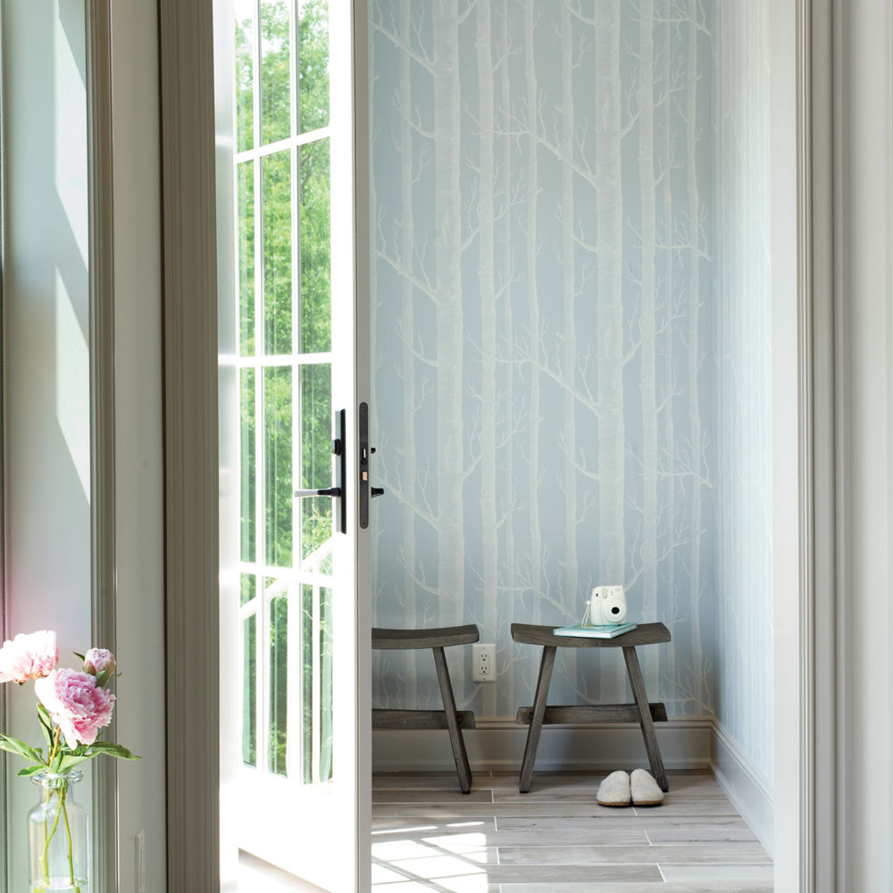 A coastal entryway with blue wallpaper and white painted walls.