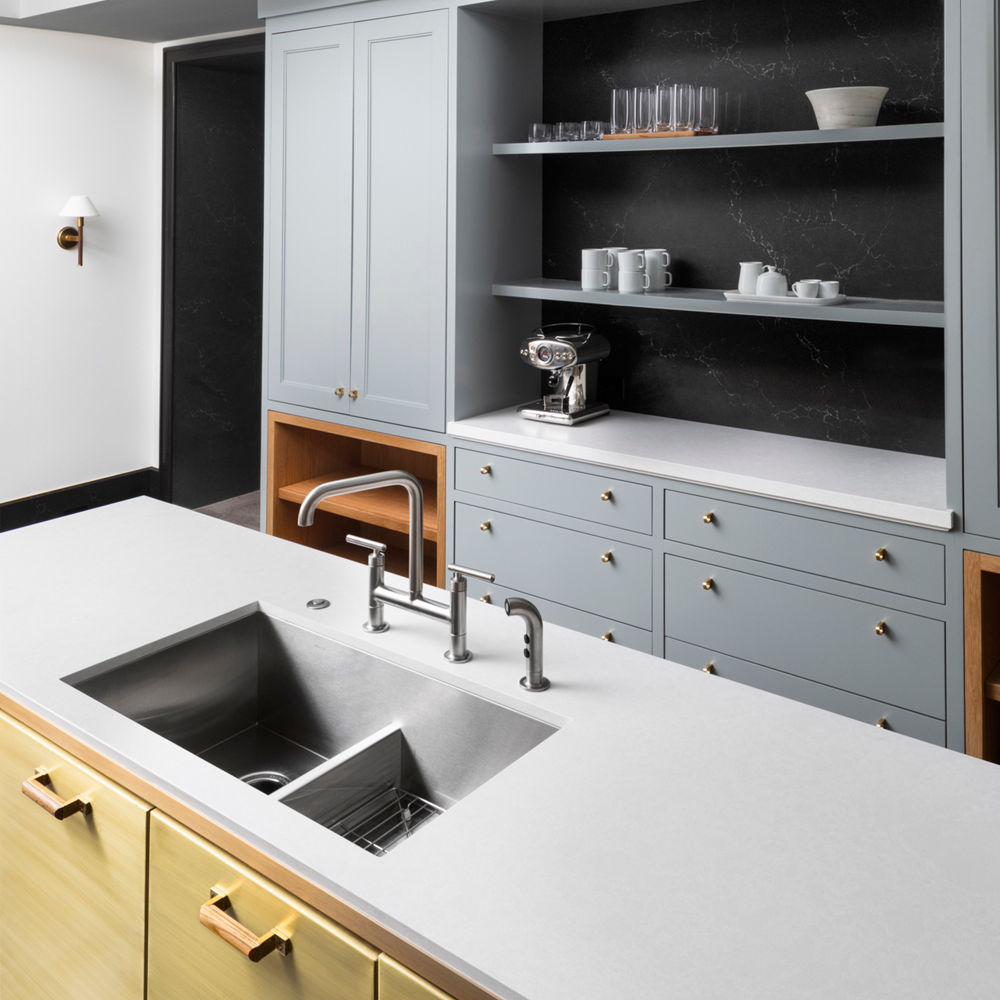 A kitchen with an island utilizing both Cambria Charlestown and Cambria Foggy City quartz.