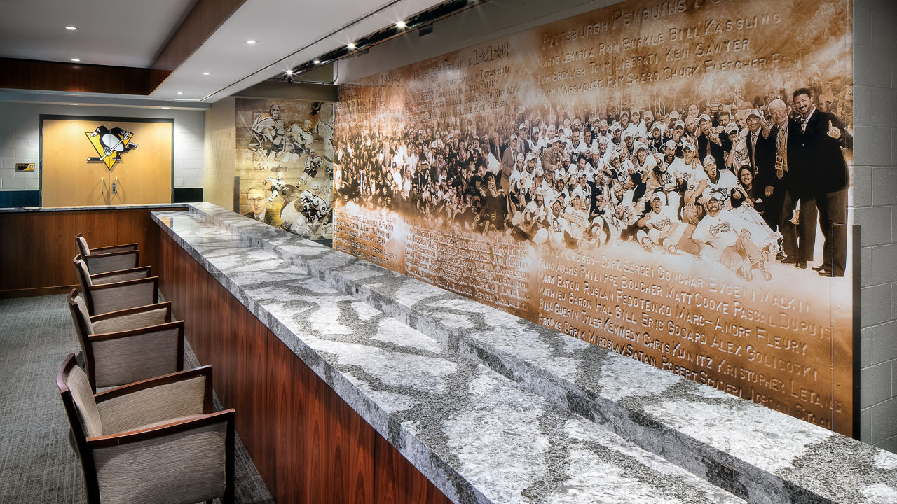 A suite in the Pittsburgh Penguin's Arena featuring a bar topped with white and gray veined quartz countertops.