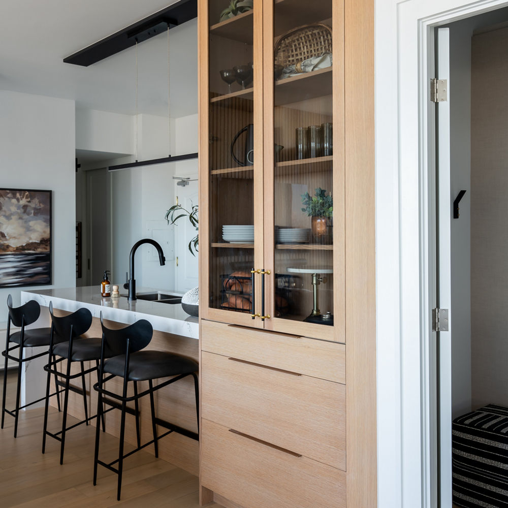 Cambria Hawksmoore countertop breakfast bar attached to tan floor-to-ceiling curio cabinet 