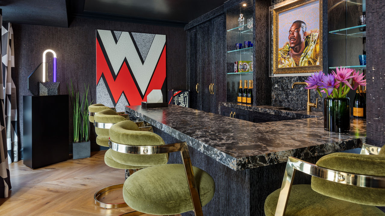 A bar featuring green chairs in front of a counter with a Cambria Hollinsbrook quartz countertop.