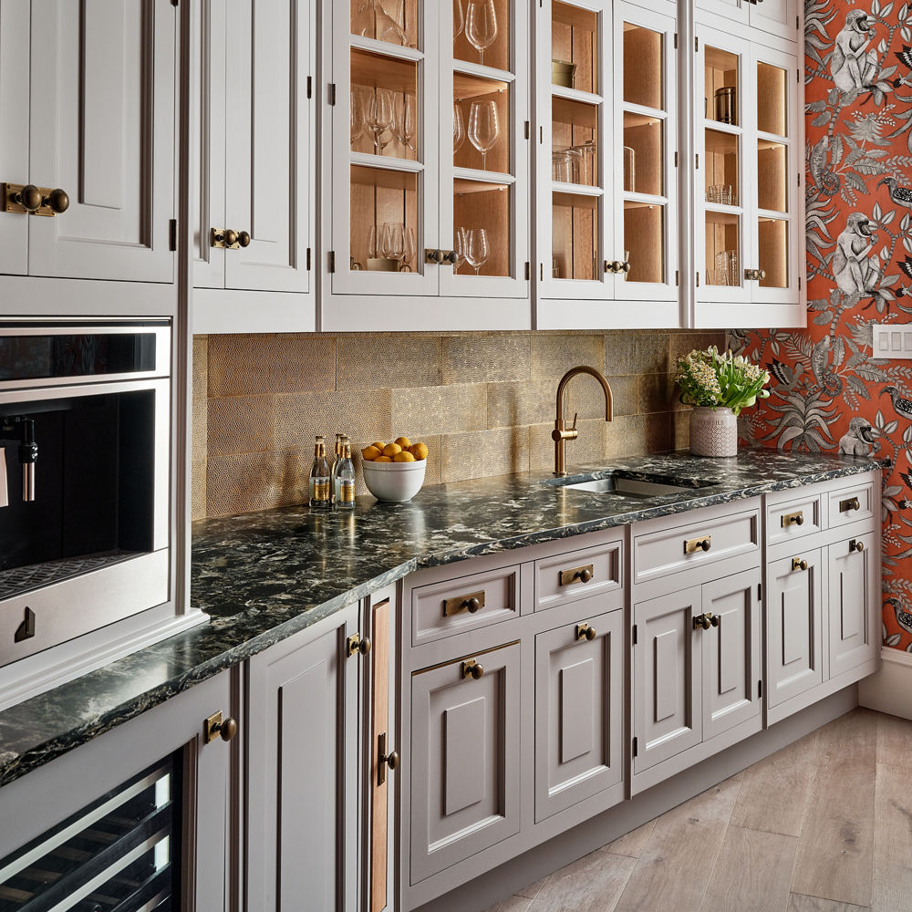 A kitchen with white upper cabinets and gray lower cabinets, with floral wallpaper and Hollinsbrook Matte Quartz Countertops