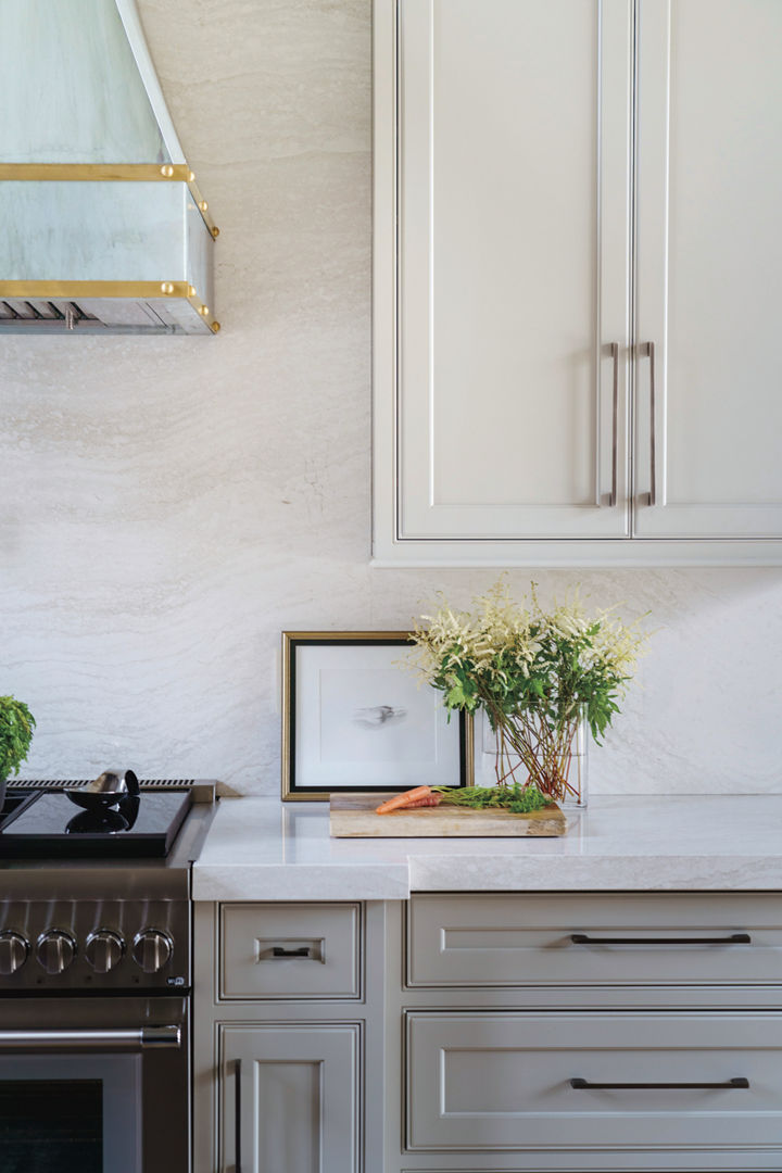 a kitchen with gray cabinets, white quartz countertops and backsplash, and white upper cabinets.