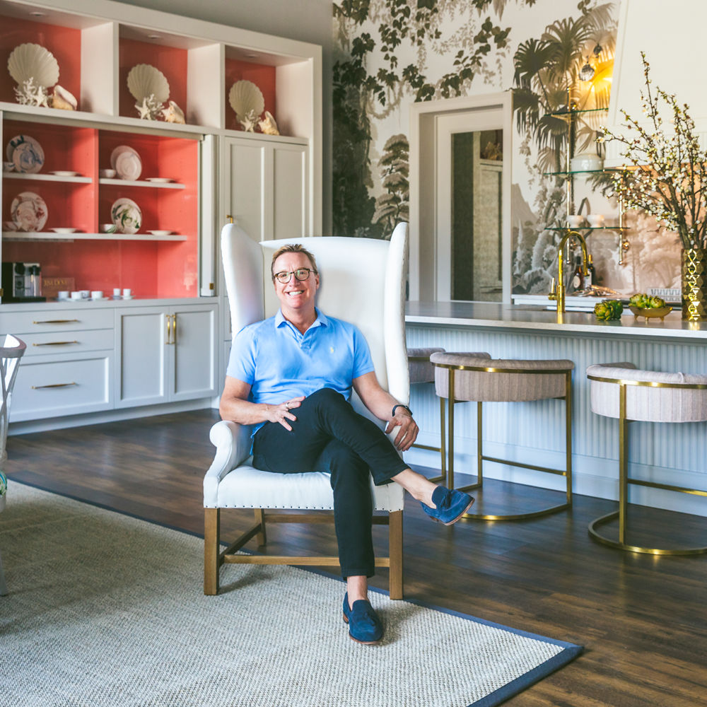 Designer Jim Dove sitting in a chair in front of an island countertop with Cambria Ironsbridge Matte Quartz