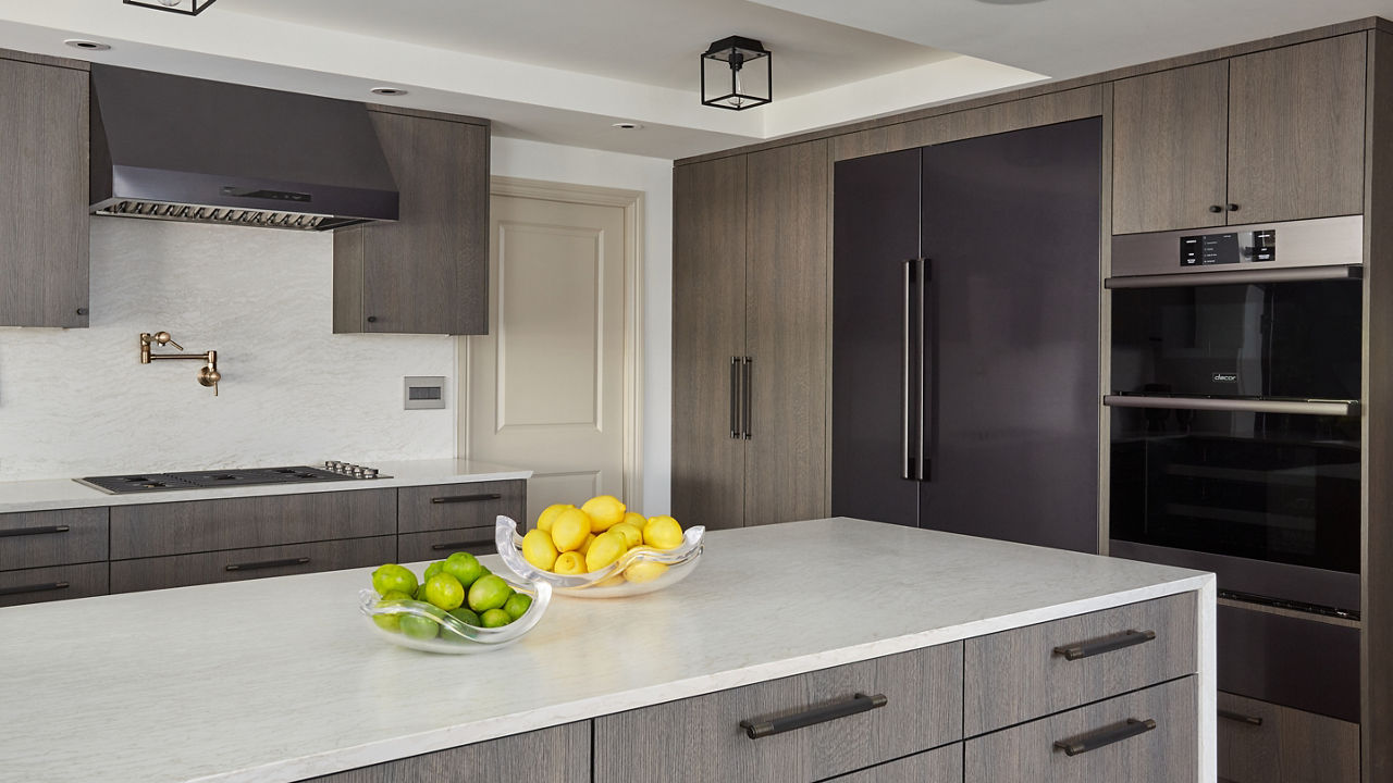 A sleek gray and white kitchen with Cambria ironsbridge matte countertops
